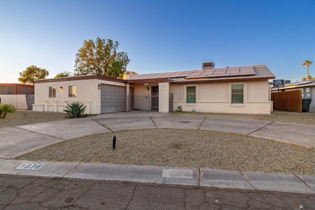 1836 W Allen St, Yuma, AZ 85364 - view of front of home featuring an attached garage, roof mounted solar panels, concrete driveway, brick siding, and stucco siding