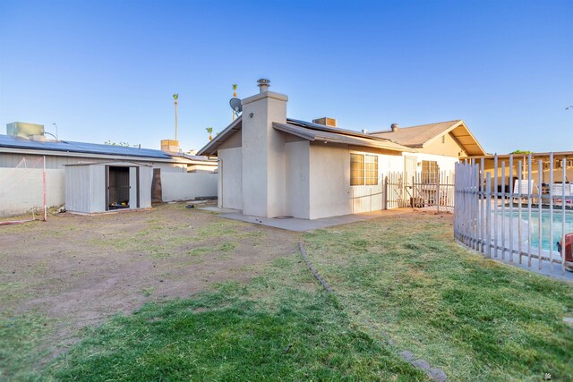1836 W Allen St, Yuma, AZ 85364 - back of house with a storage unit, a fenced backyard, and stucco siding