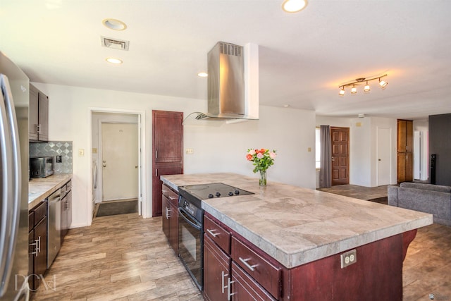 kitchen with visible vents, wall chimney range hood, reddish brown cabinets, light countertops, and black appliances