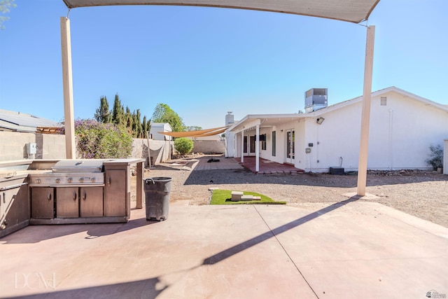view of patio / terrace with an outdoor kitchen, central AC unit, a fenced backyard, and area for grilling