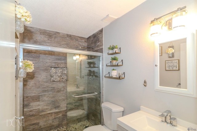 bathroom featuring vanity, visible vents, toilet, and a shower stall