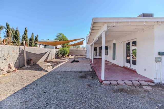 view of yard featuring french doors, a fenced backyard, and a patio area