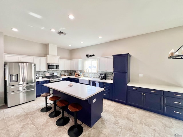 3431 W 39th Pl, Yuma, AZ 85365 - kitchen with stainless steel appliances, blue cabinets, backsplash, a kitchen island, and recessed lighting