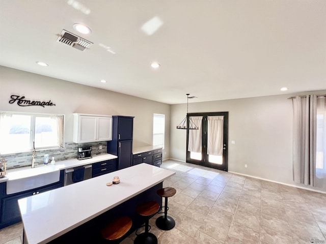 3431 W 39th Pl, Yuma, AZ 85365 - kitchen with blue cabinetry, light countertops, a sink, a breakfast bar area, and a kitchen island