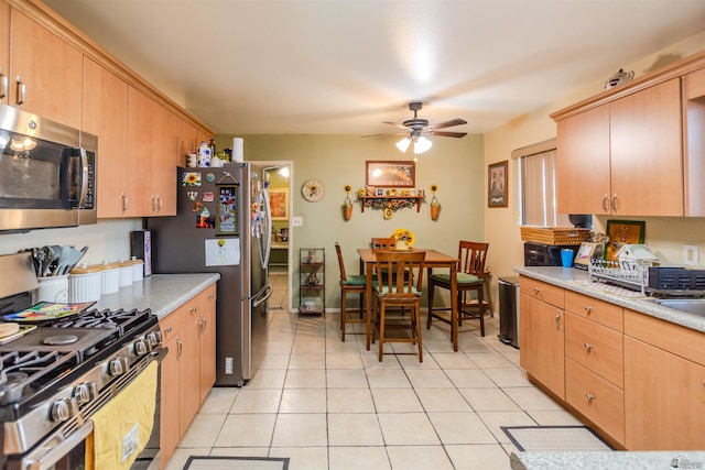 1180 E 26th Pl, Yuma, AZ 85365 - kitchen with stainless steel appliances, light tile patterned floors, a ceiling fan, and light countertops