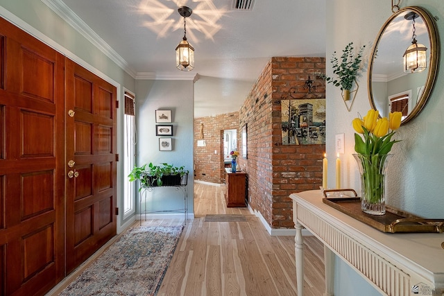 entryway with a healthy amount of sunlight, baseboards, light wood-type flooring, and brick wall