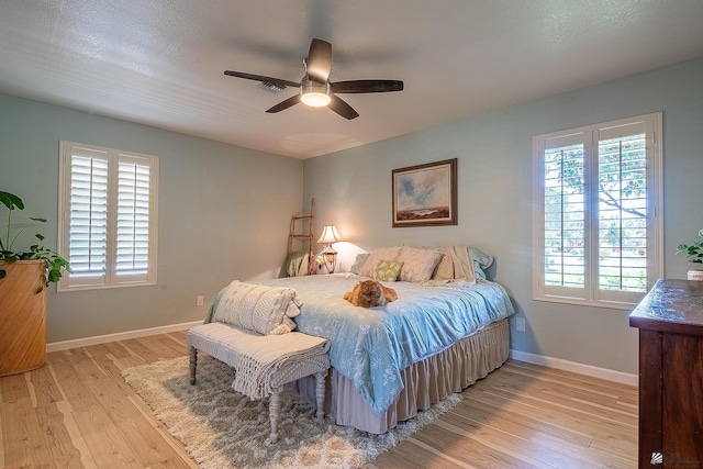 bedroom featuring baseboards, ceiling fan, and light wood-style flooring