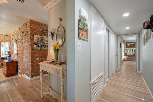 hall with recessed lighting, baseboards, brick wall, and light wood-type flooring