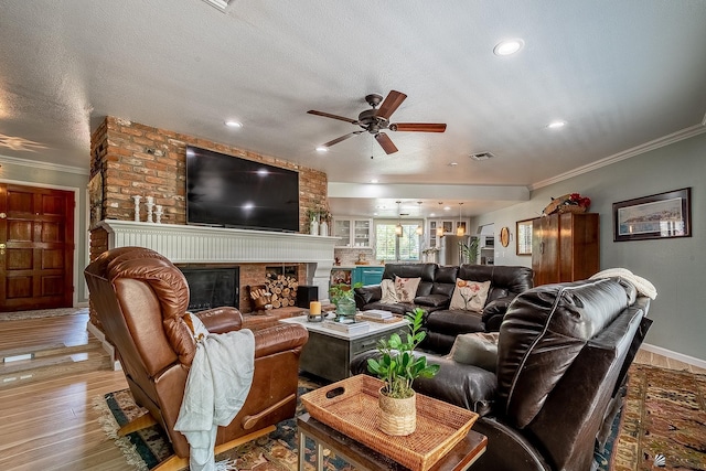 living room with crown molding, wood finished floors, a fireplace, ceiling fan, and recessed lighting