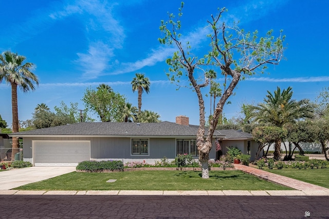 ranch-style home with a chimney, an attached garage, concrete driveway, and a front yard