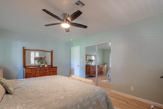 bedroom featuring visible vents, a closet, light wood-style floors, baseboards, and a ceiling fan