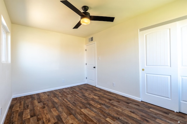 unfurnished bedroom with dark wood-style flooring, baseboards, visible vents, and a ceiling fan