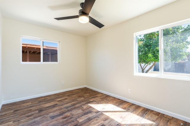 empty room with dark wood-style flooring, baseboards, and a ceiling fan