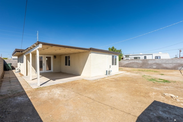 back of property with an attached carport, a fenced backyard, a patio area, and stucco siding