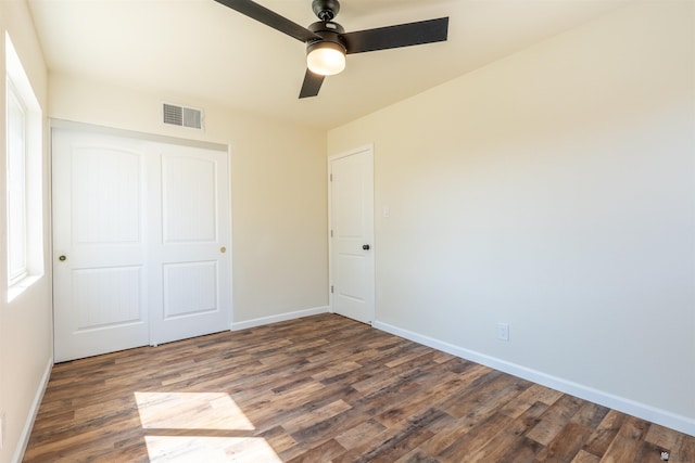 unfurnished bedroom featuring baseboards, visible vents, and wood finished floors