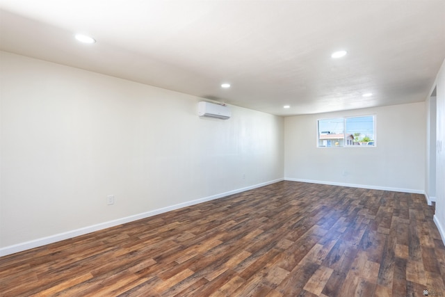 below grade area featuring dark wood-style flooring, recessed lighting, and a wall mounted air conditioner