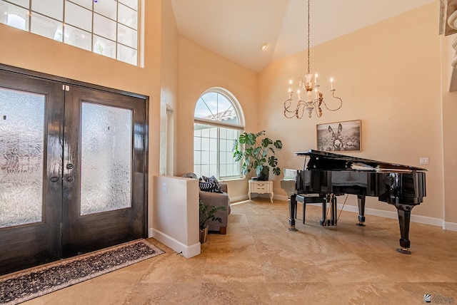 foyer with french doors, a chandelier, high vaulted ceiling, and baseboards