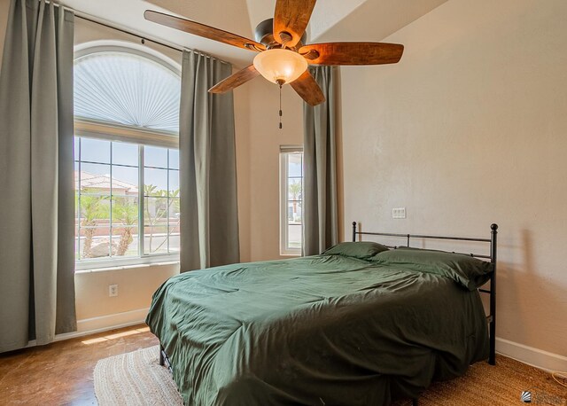 bedroom featuring a barn door, a tray ceiling, concrete floors, baseboards, and recessed lighting