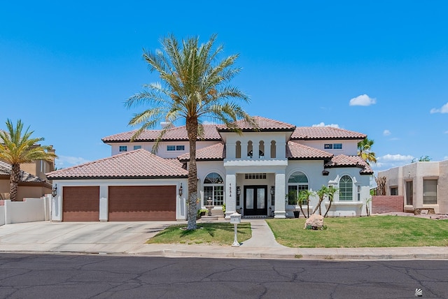 mediterranean / spanish-style house with french doors, stucco siding, a garage, concrete driveway, and a tile roof