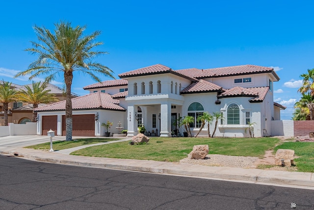 mediterranean / spanish-style house featuring stucco siding, an attached garage, a tiled roof, and concrete driveway