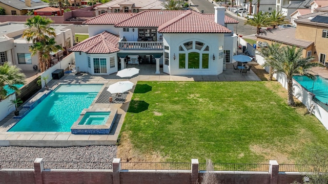 rear view of house featuring a residential view, a balcony, stucco siding, and a patio area