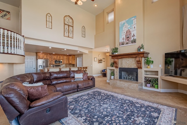 living area featuring a high ceiling, a fireplace, baseboards, and recessed lighting