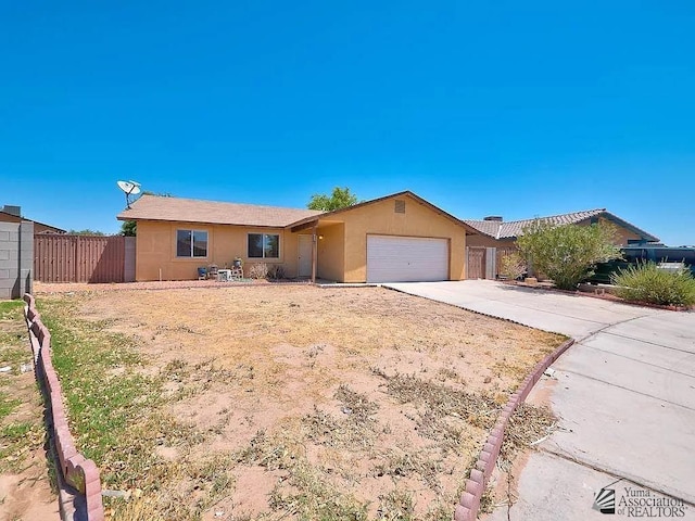 ranch-style home featuring a garage, fence, stucco siding, and concrete driveway