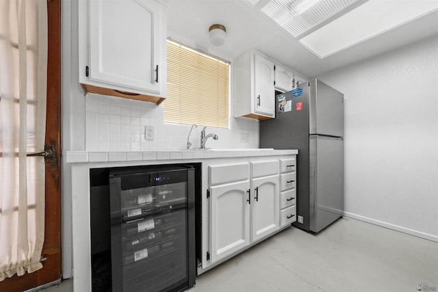 2045 S 14th Ave Unit 74, Yuma, AZ 85364 - kitchen with beverage cooler, freestanding refrigerator, white cabinetry, tasteful backsplash, and baseboards