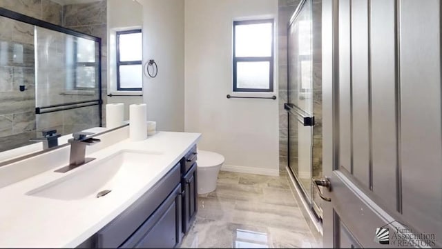 bathroom with toilet, vanity, and walk in shower