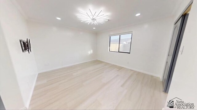 spare room featuring light hardwood / wood-style floors and ornamental molding