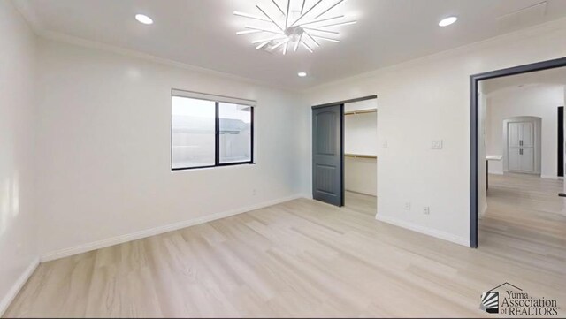 unfurnished bedroom featuring light wood-type flooring, an inviting chandelier, a closet, and crown molding