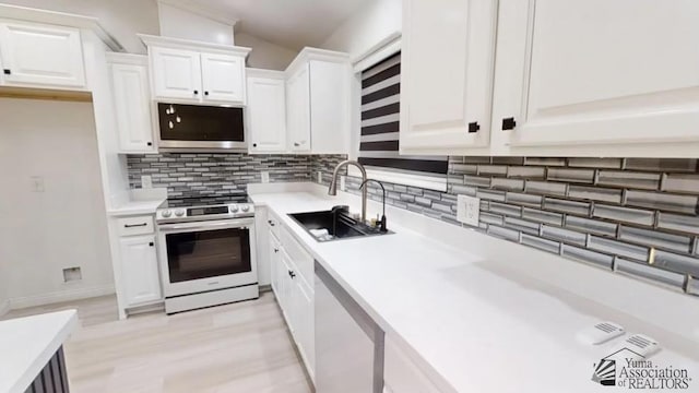 kitchen featuring backsplash, sink, white cabinets, and stainless steel appliances