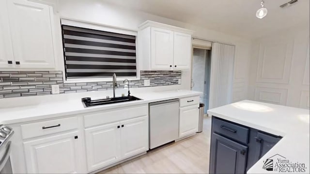 kitchen with sink, tasteful backsplash, white dishwasher, white cabinets, and range