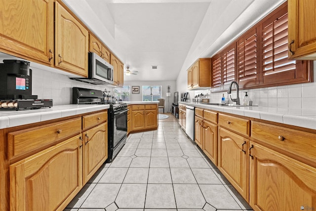 3875 W 26th St, Yuma, AZ 85364 - kitchen with stainless steel appliances, tasteful backsplash, tile countertops, light tile patterned floors, and ceiling fan