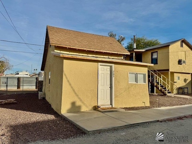 249 S 9th Ave, Yuma, AZ 85364 - rear view of property featuring fence, stairs, and stucco siding