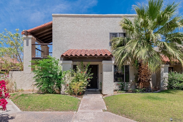 2231 S Elks Ln # 77, Yuma, AZ 85364 - view of front facade with stucco siding, a balcony, and a front yard