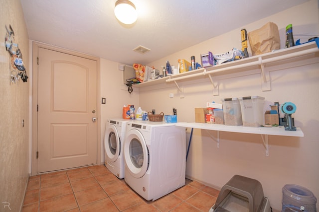laundry room featuring light tile patterned floors, laundry area, and washing machine and dryer