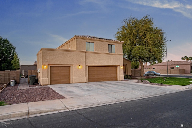 view of front of home featuring stucco siding, a garage, fence, and concrete driveway