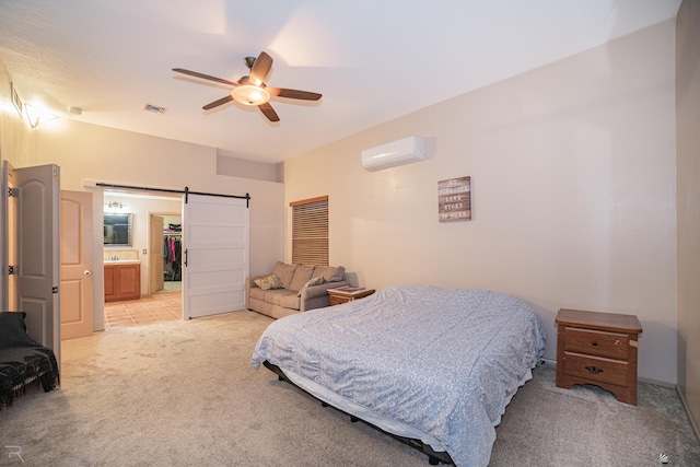 bedroom featuring visible vents, light carpet, an AC wall unit, a barn door, and a ceiling fan