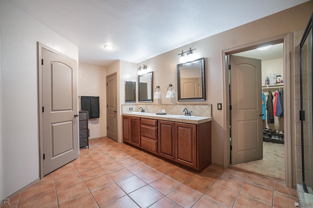 full bath with a sink, decorative backsplash, tile patterned flooring, and double vanity