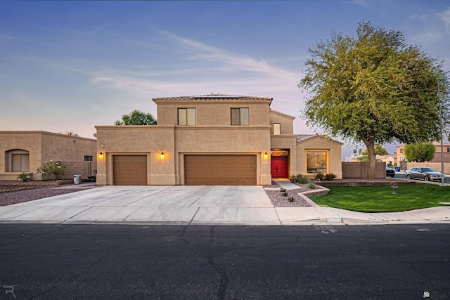view of front facade with a garage, fence, stucco siding, and driveway