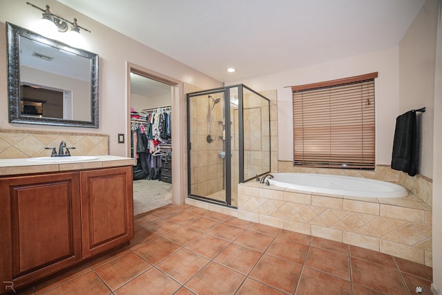 bathroom with visible vents, tile patterned flooring, a walk in closet, and a stall shower