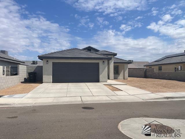 4680 E San Pedro St, San Luis, AZ 85336 - view of front of property with a garage, stucco siding, a tile roof, fence, and driveway
