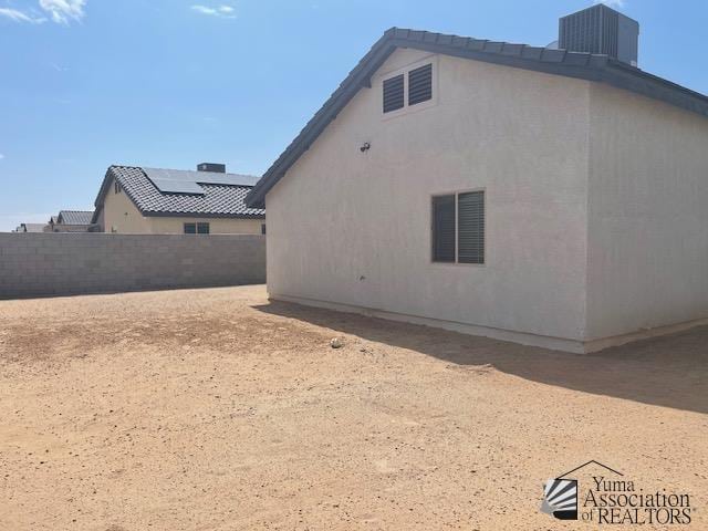 4680 E San Pedro St, San Luis, AZ 85336 - view of side of property with central AC unit, fence, and stucco siding