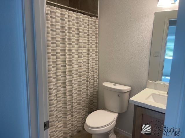 4680 E San Pedro St, San Luis, AZ 85336 - bathroom featuring vanity, toilet, a shower with shower curtain, and a textured wall