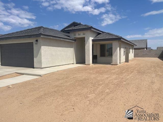 4680 E San Pedro St, San Luis, AZ 85336 - prairie-style home featuring concrete driveway, a tiled roof, stucco siding, and a garage