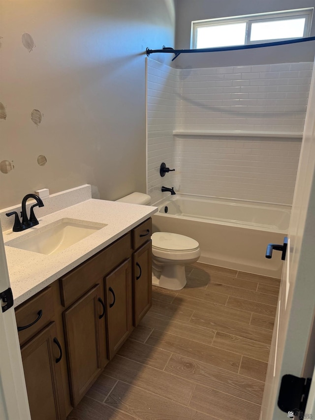 bathroom with toilet, shower / tub combination, wood finished floors, and vanity