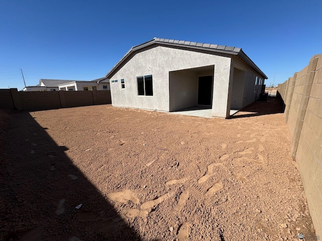 back of property featuring a fenced backyard and stucco siding