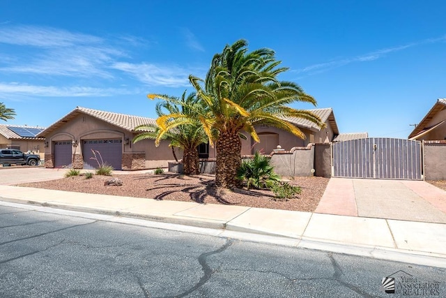 5492 E View Pkwy, Yuma, AZ 85365 - view of front facade with driveway, a gate, stucco siding, a garage, and fence