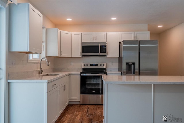 kitchen featuring appliances with stainless steel finishes, dark hardwood / wood-style floors, white cabinetry, and sink